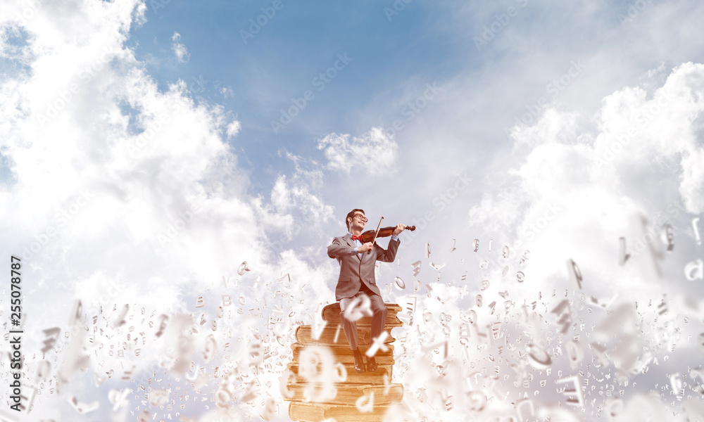 Handsome violinist play his melody and symbols fly around in air