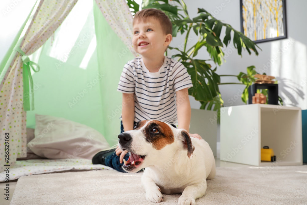 Cute little boy with funny dog at home