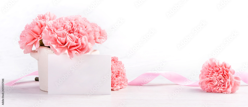 Beautiful blooming baby pink tender carnations in a white vase isolated on bright background, may mo