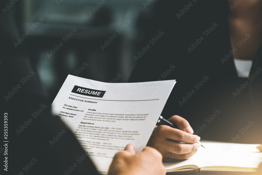 Human resources department manager reads CV resume document of an employee candidate at interview ro