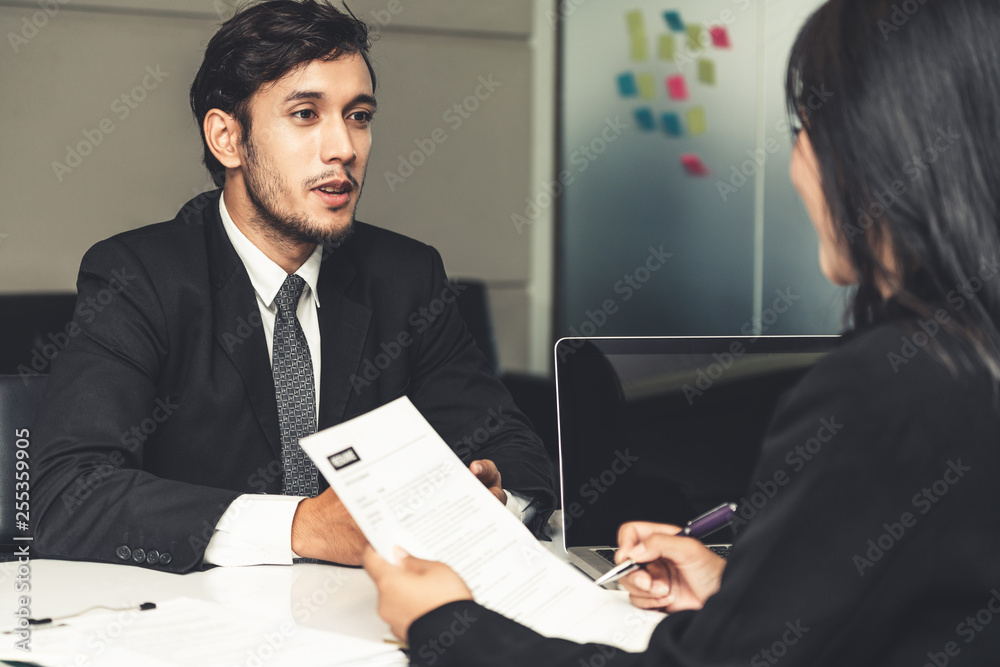 Human resource manager interviewing the male employment candidate in the office room. Happy job inte