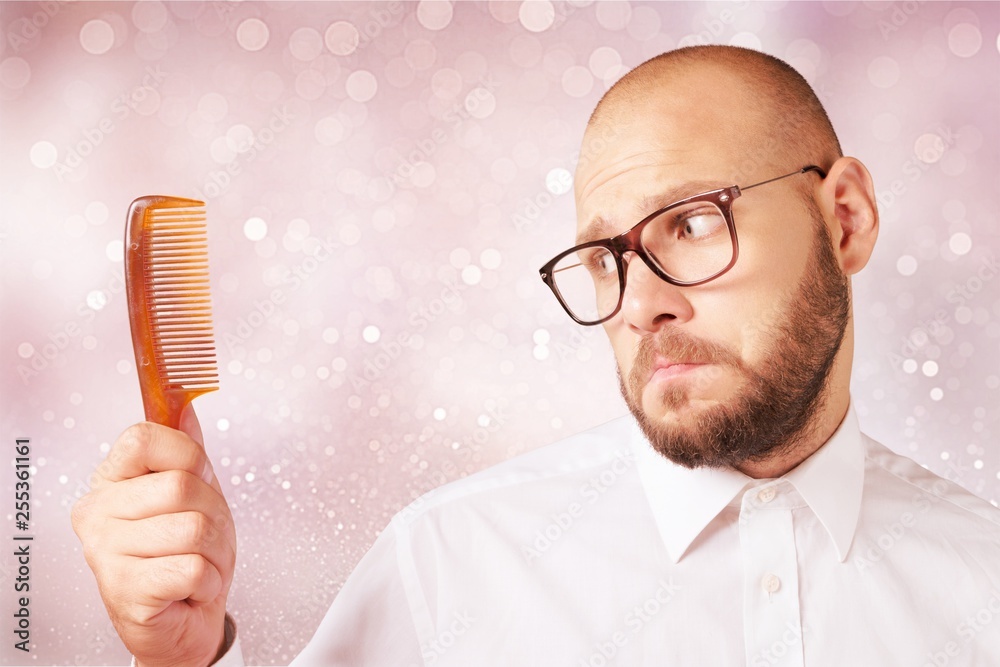 Adult bald  man hand holding comb