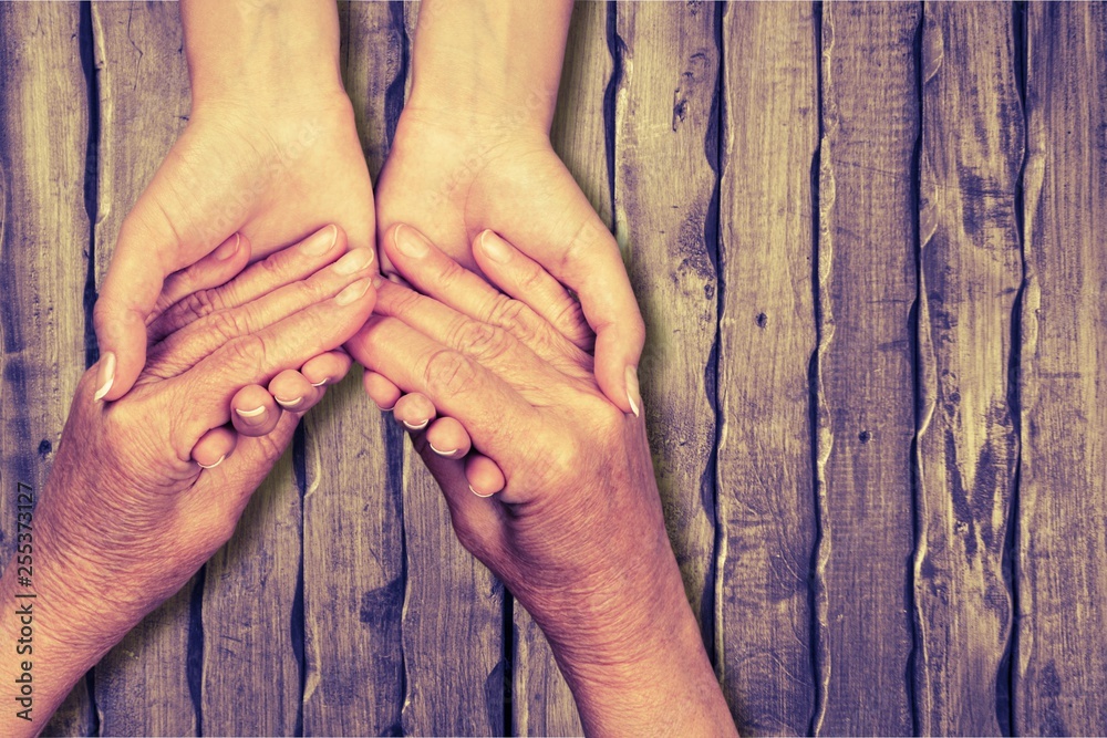 Hands of man and woman holding together over background