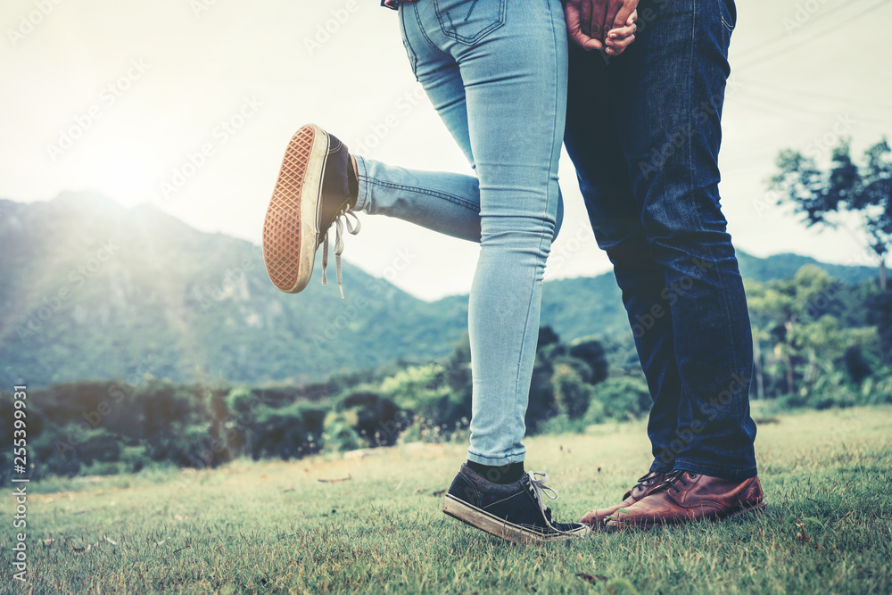 Happy couple take a romantic walk in green grass field on the hills. Travel and honeymoon concept.