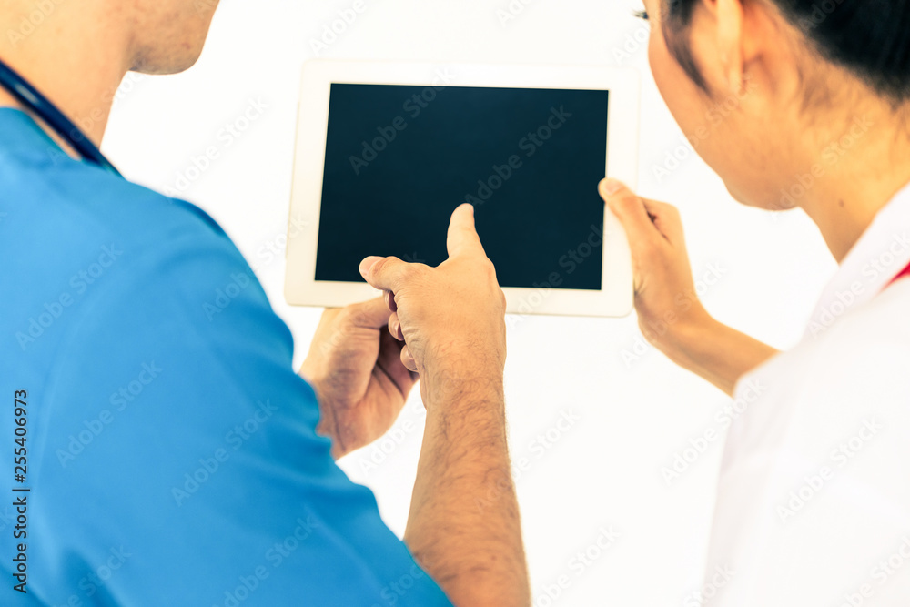 Female doctor using tablet computer while discussing with another doctor at the hospital. Medical he