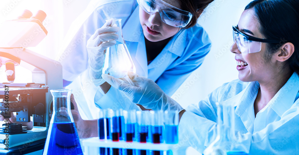 Group of scientists wearing lab coat working in laboratory while examining biochemistry sample in te