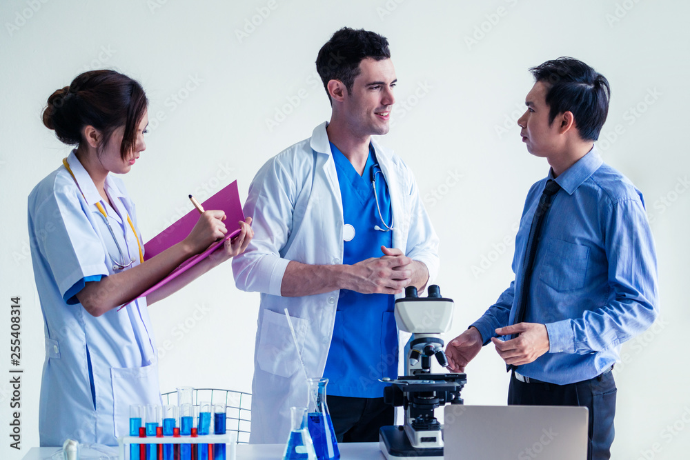 Group of scientists wearing lab coat working in laboratory while examining biochemistry sample in te