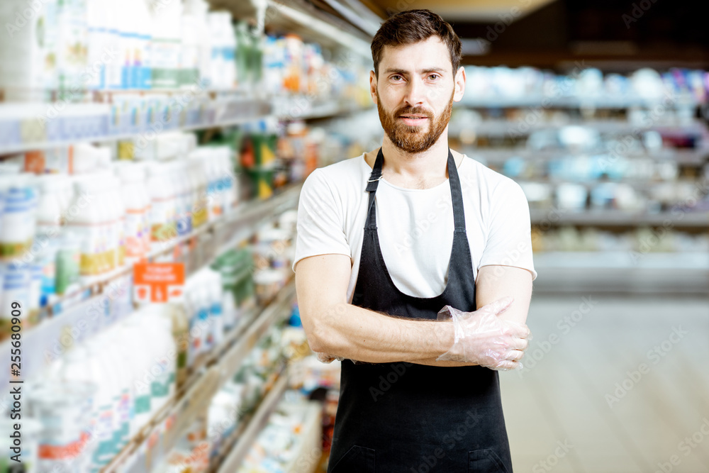 一位英俊的店员或送奶工拿着乳制品站在自己身边的肖像