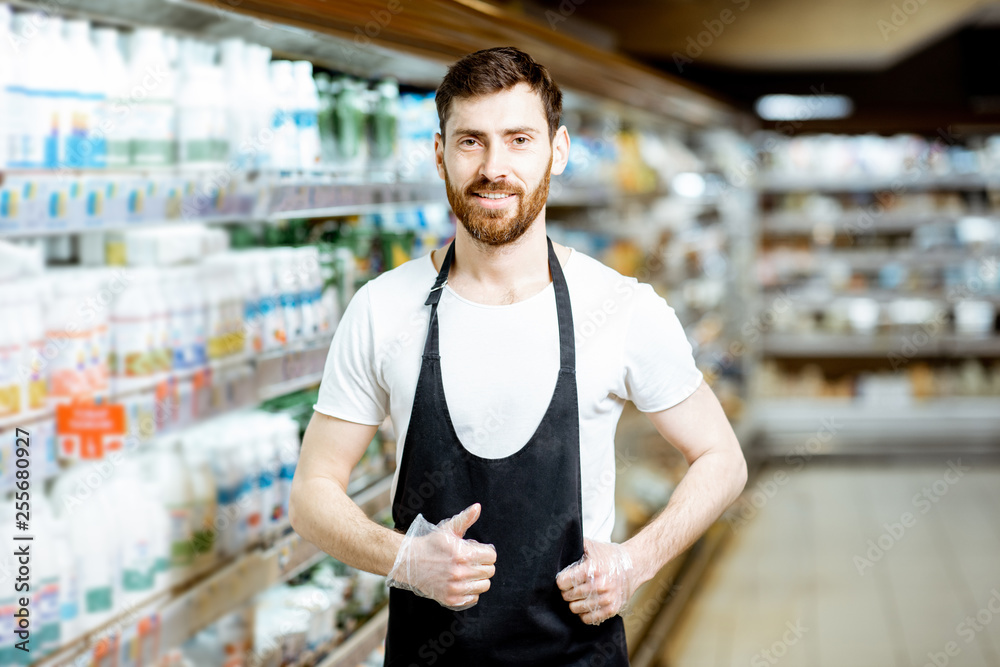 一位英俊的店员或送奶工拿着乳制品站在自己身边的肖像