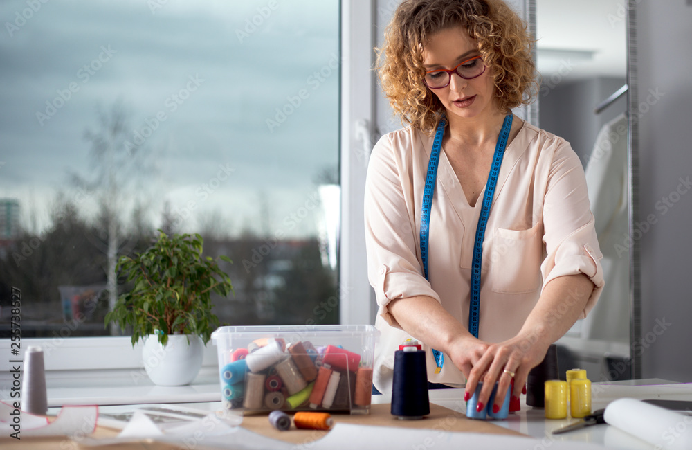 Professional female tailor over work desk at fashion design workshop