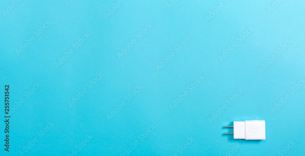 Charger plug adapter on a blue paper background