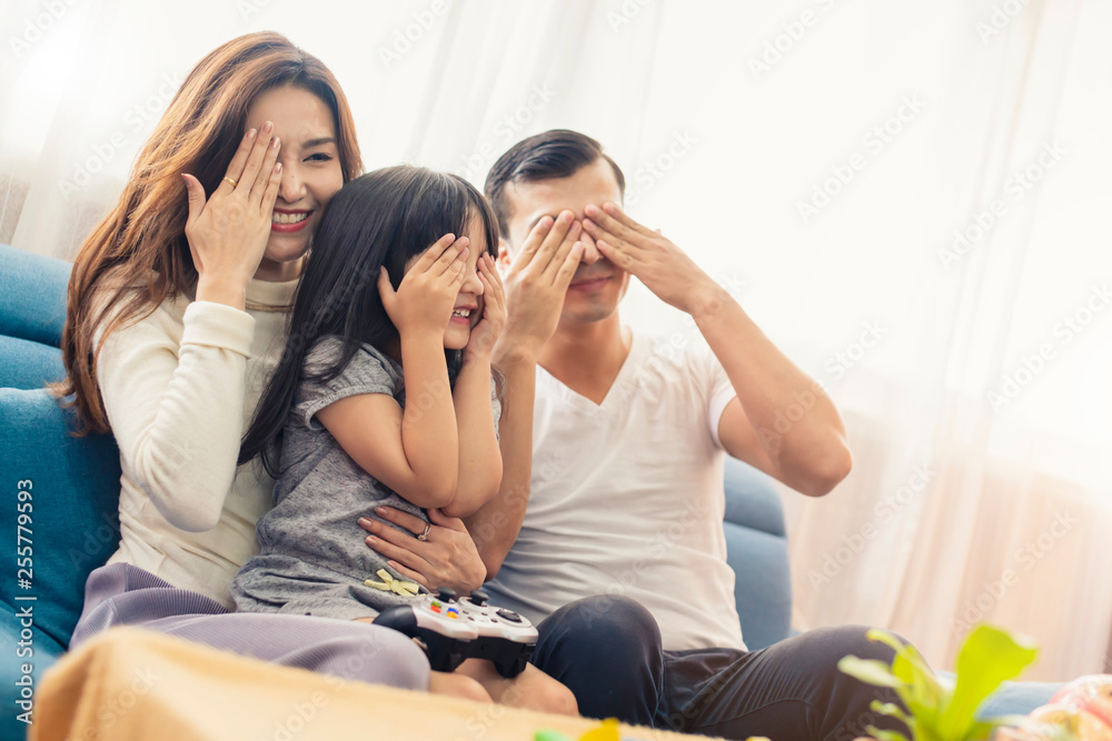 幸福的家庭混血妈妈爸爸和女儿喜欢周末一起看电视节目或玩游戏