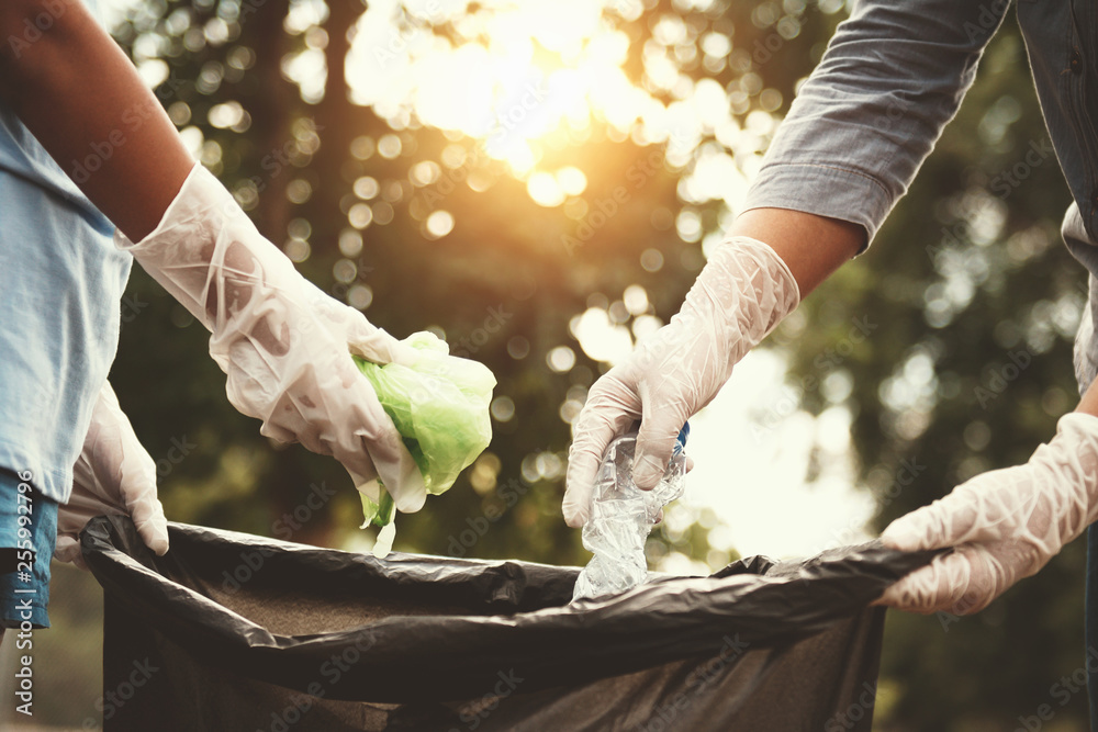 woman hand picking up garbage plastic for cleaning at park