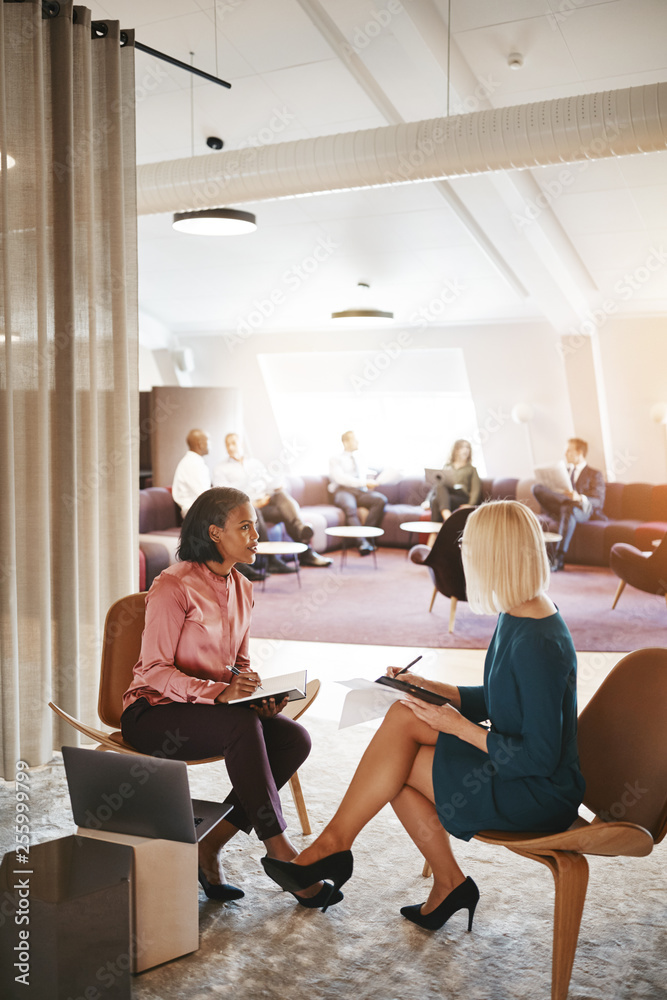 Two business colleagues discussing paperwork in an office