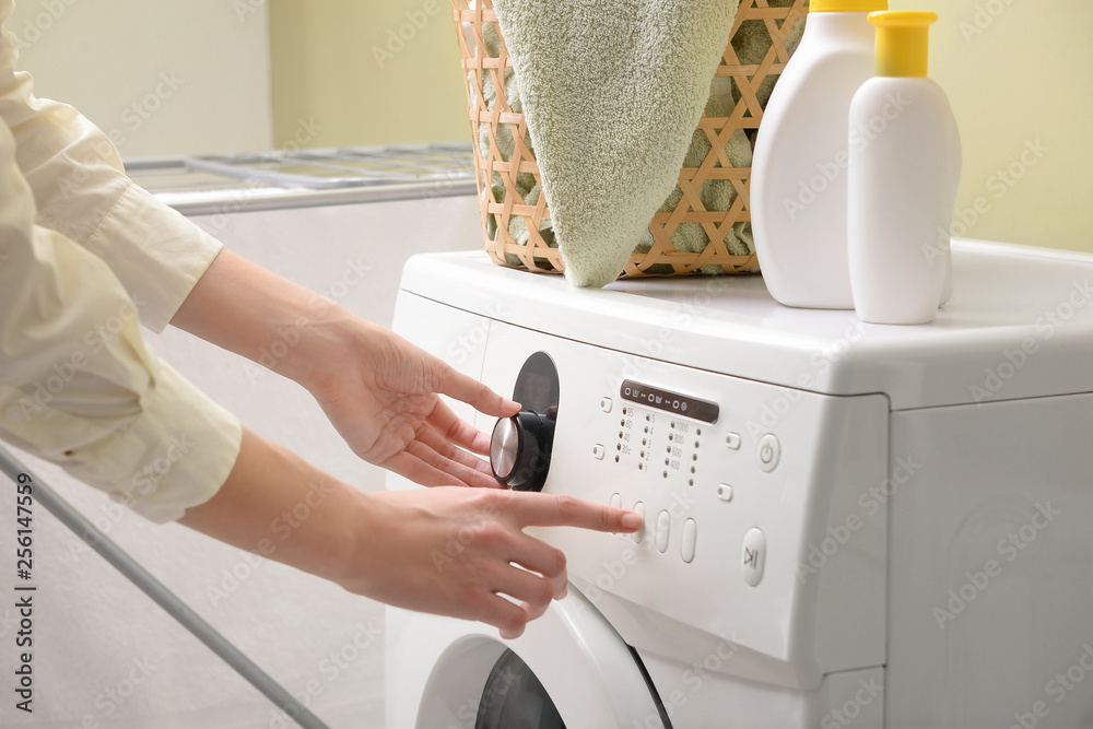 Woman switching on washing machine