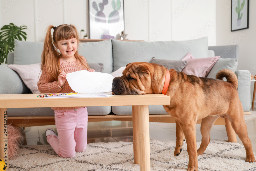 Cute little girl with funny dog at home