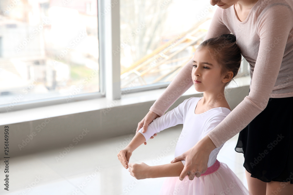 Little ballerina training with coach in dance studio