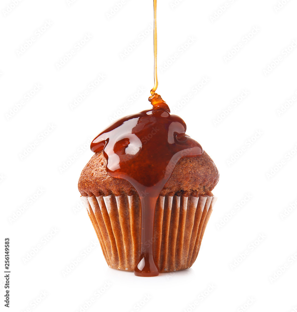 Liquid caramel pouring on muffin against white background