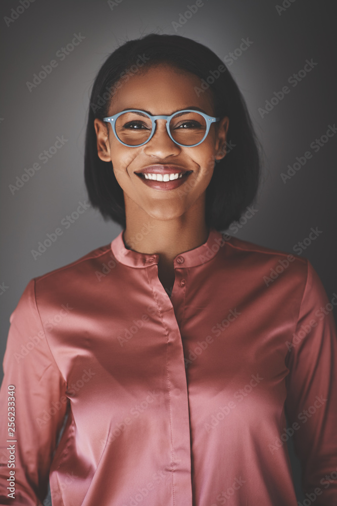 Young African businesswoman smiling while standing against a gra