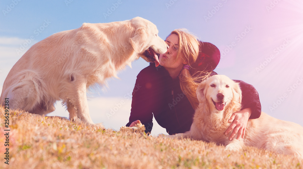 Perros graciosos. Golden retriever. Mujer joven y sus mascotas pasando un rato divertido al aire lib