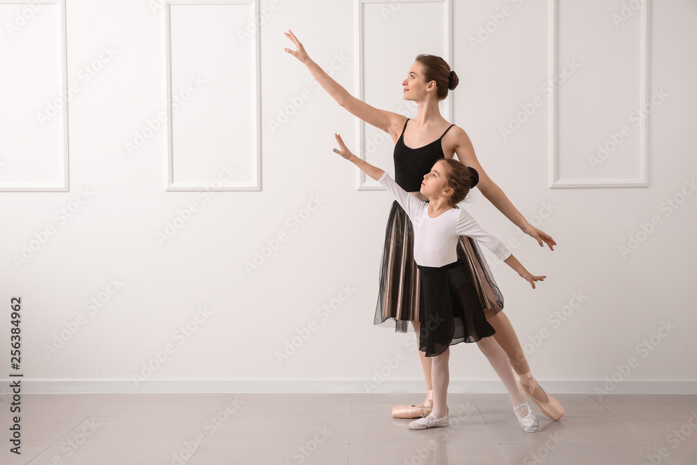 Little ballerina training with coach in dance studio