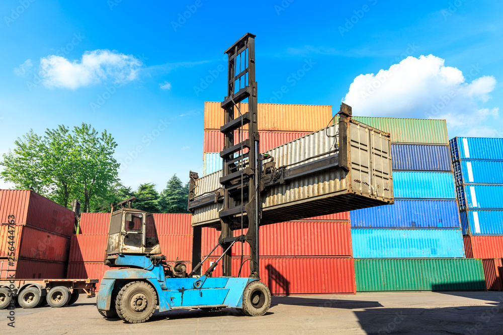 Forklift container loading and unloading cargo into the import-export zone