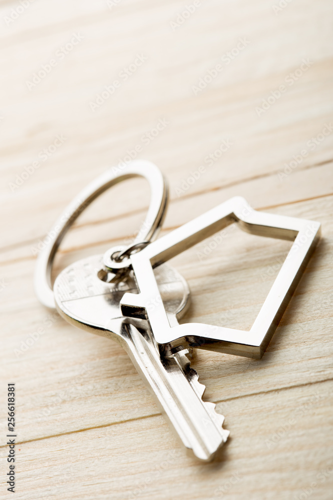 House key with a keychain on wooden desk concept for real estate