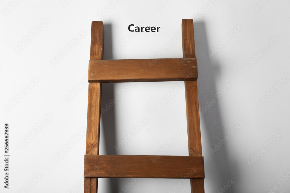 Wooden ladder near light wall. Concept of career growth