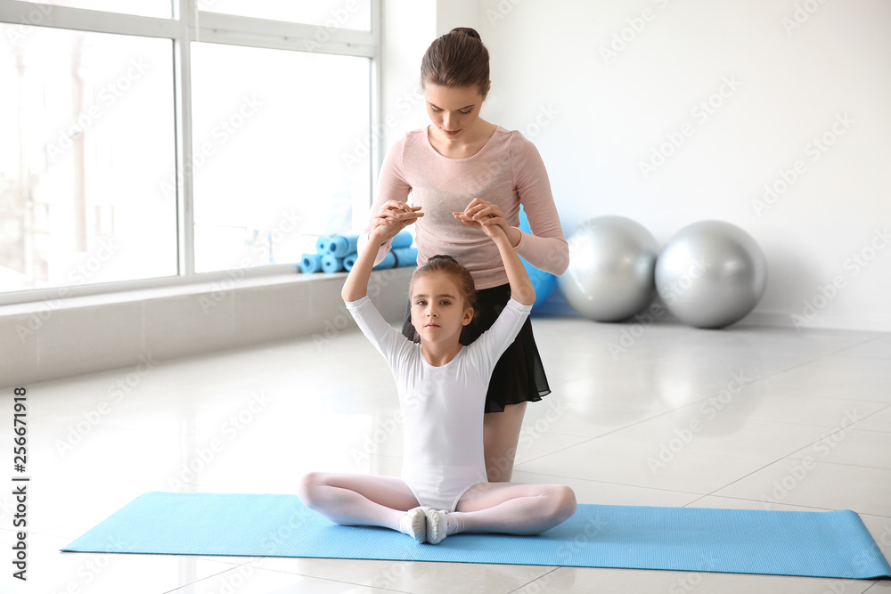 Little ballerina training with coach in dance studio