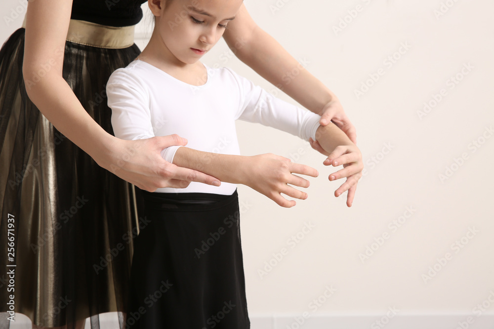 Little ballerina training with coach in dance studio