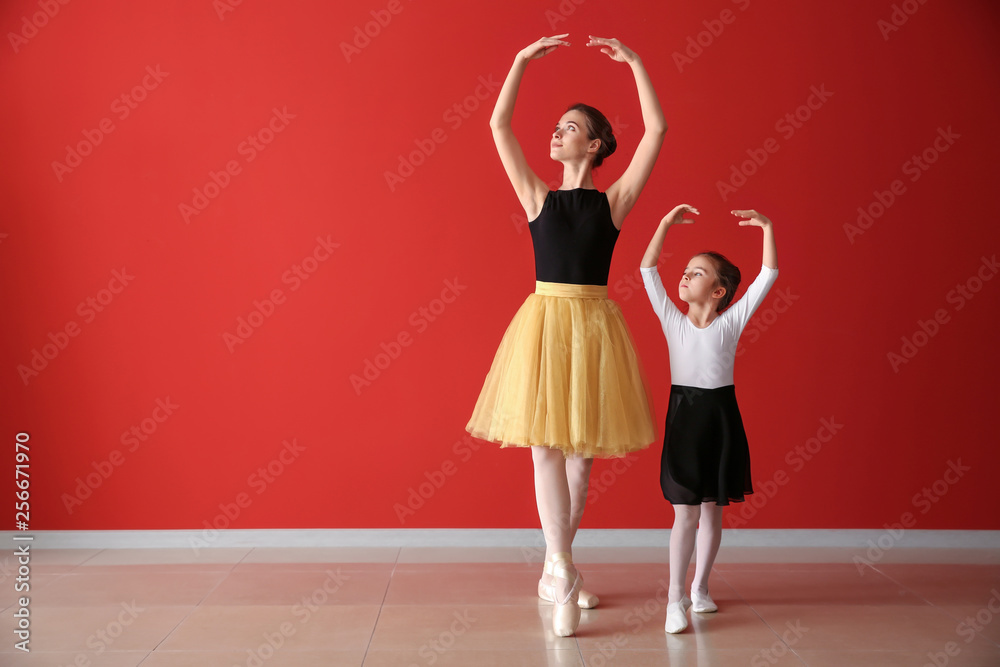 Little ballerina training with coach in dance studio