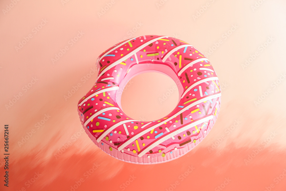 Bright inflatable ring on color background