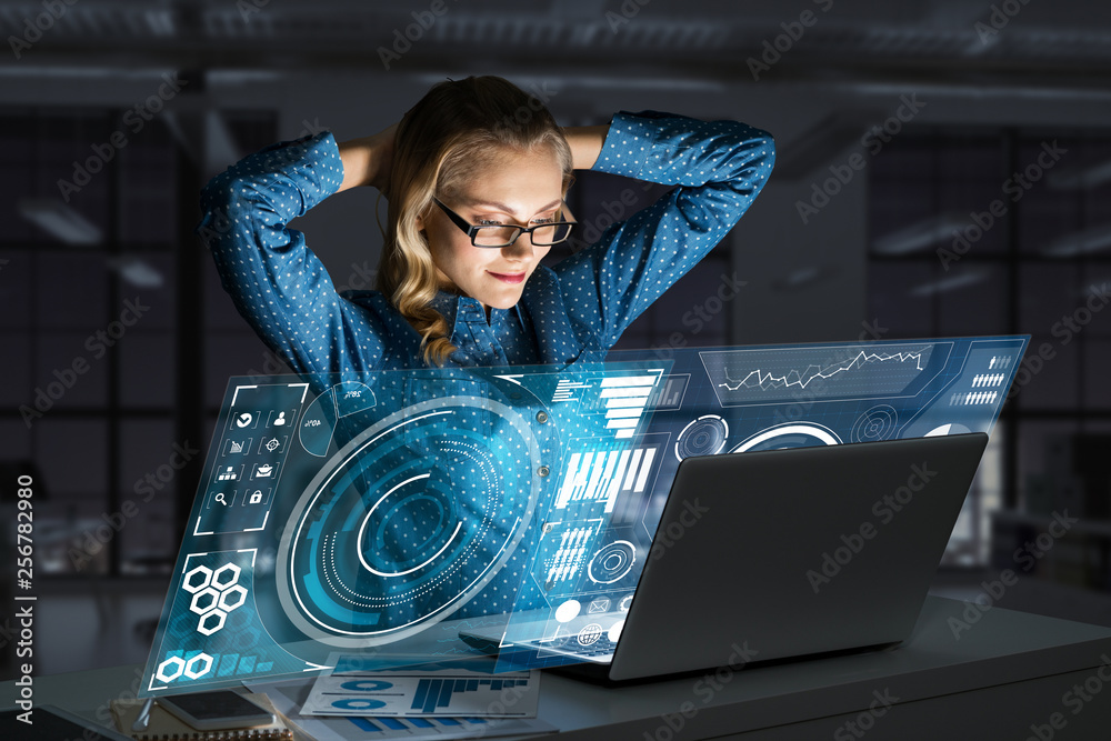 Beautiful blonde working on laptop and infographs out of screen. Mixed media