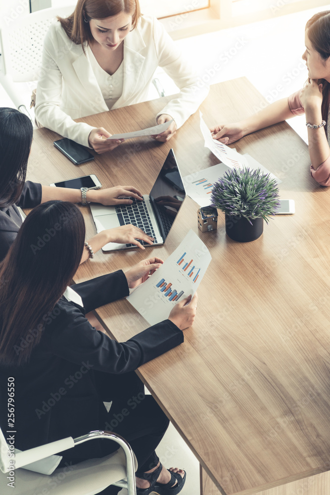 Businesswoman in group meeting discussion with other businesswomen colleagues in modern workplace of