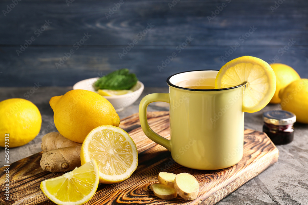 Cup of hot tea with lemon and ginger on wooden board