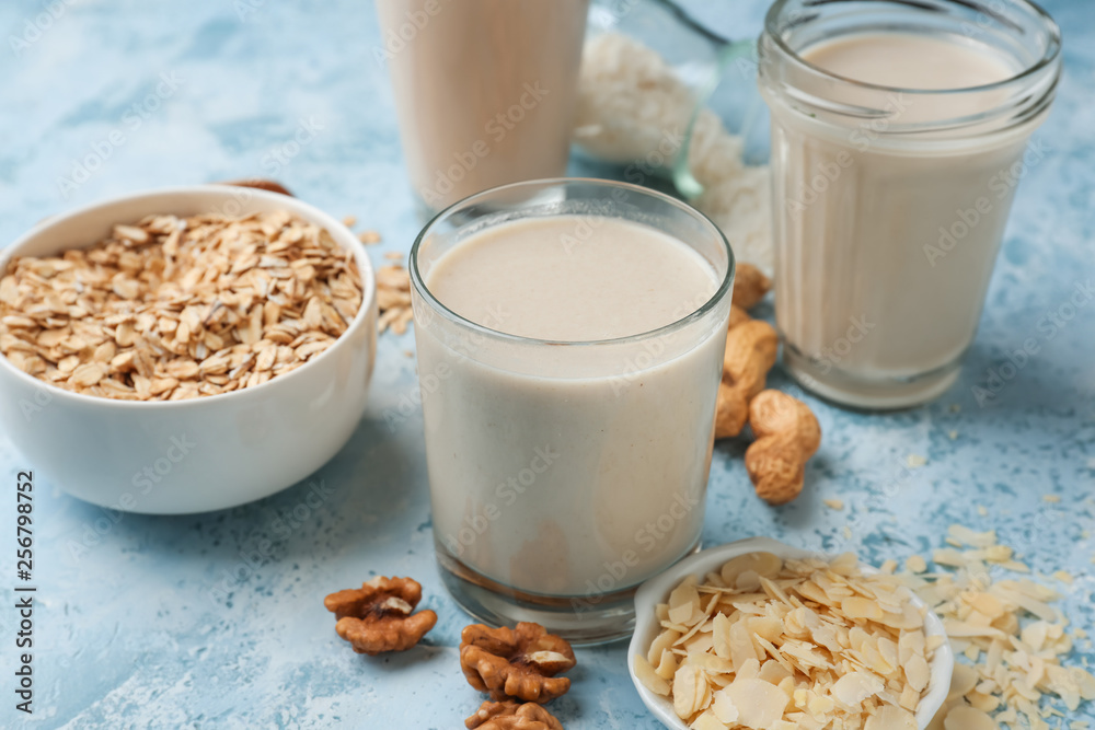 Assortment of tasty vegan milk on color background