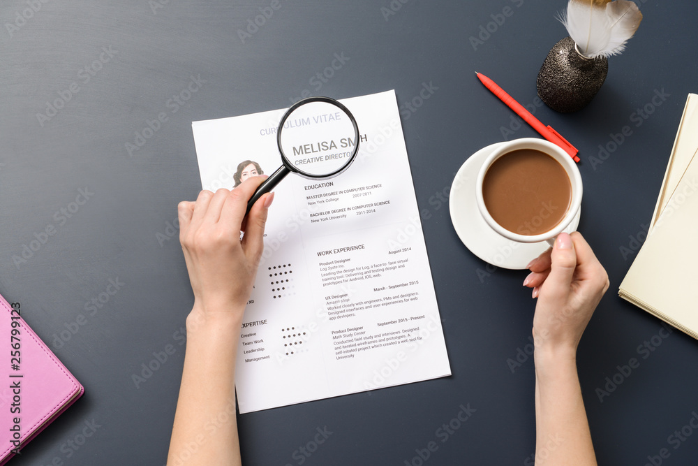 HR manager studying job resume of candidate at table