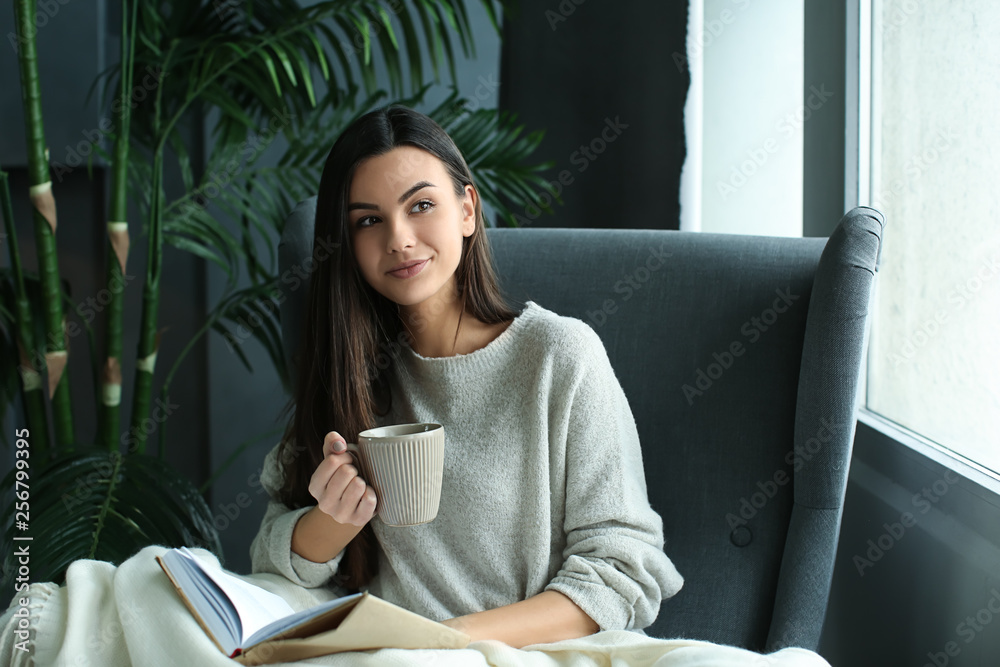 美丽的年轻女子在家看书