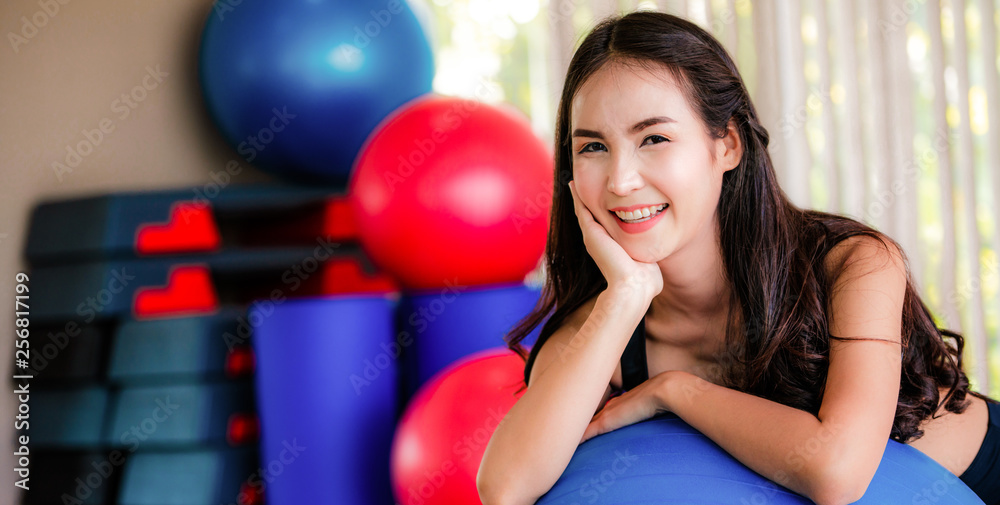 Beautiful young woman in fitness center doing pilates exercise with fitness ball. Healthy lifestyle 