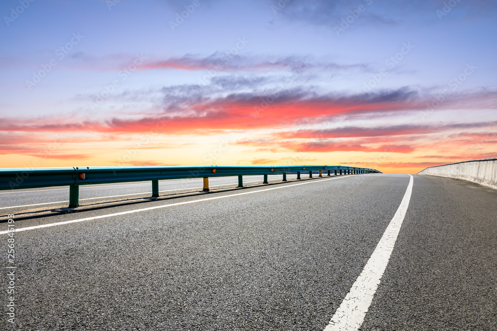 Asphalt highway ground and beautiful clouds at sunrise