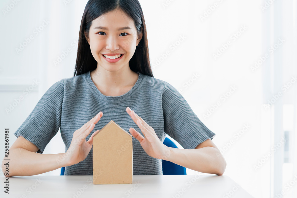 business insurance ideas concept with asian woman hand protect home paper model white background