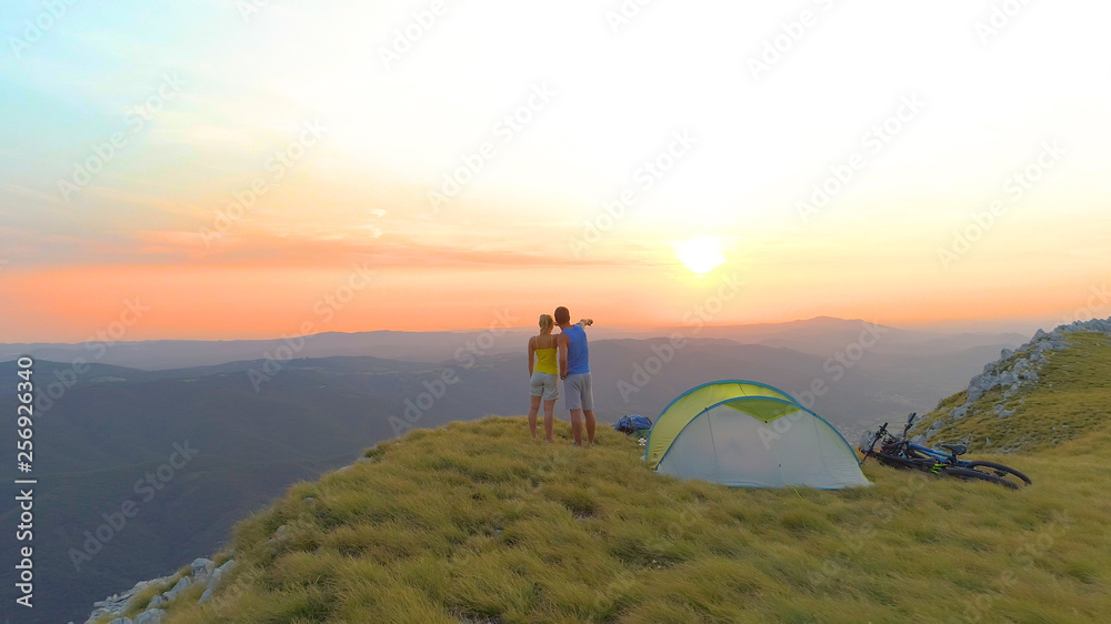 航空航天：日出时难以辨认的女人和男人在观察令人惊叹的山脉