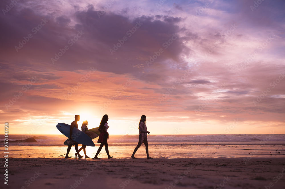 Friends walking on the beach in the evening