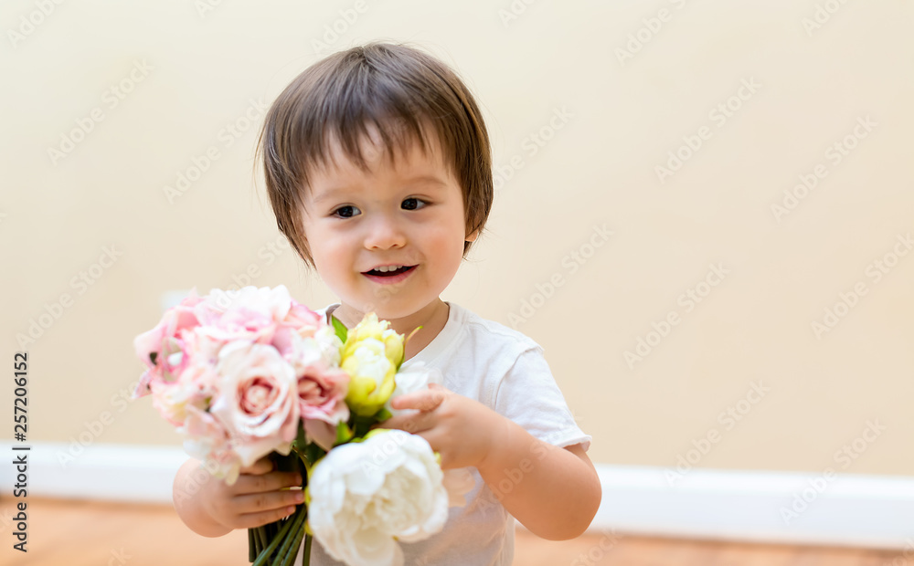 Toddler boy with a bouquet of pretty flowers