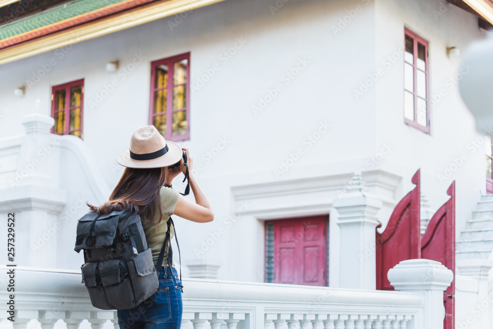 亚洲女子夏季在泰国曼谷美丽的寺庙里旅行，拍照留念