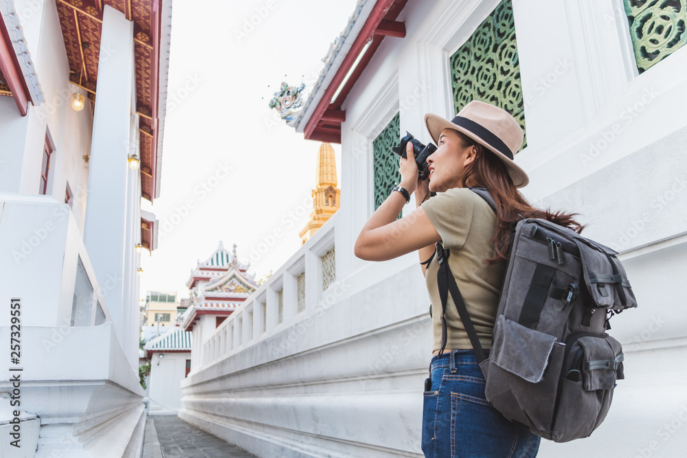 亚洲女子夏季在泰国曼谷美丽的寺庙里旅行，拍照留念