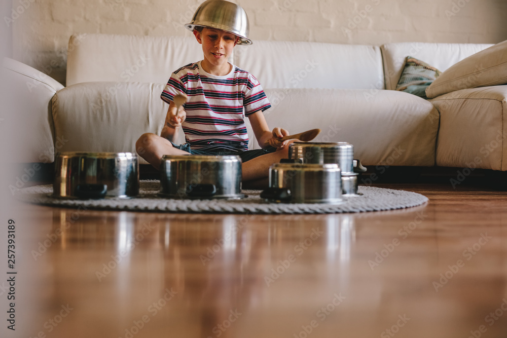 Little musician playing drums on kitchenware