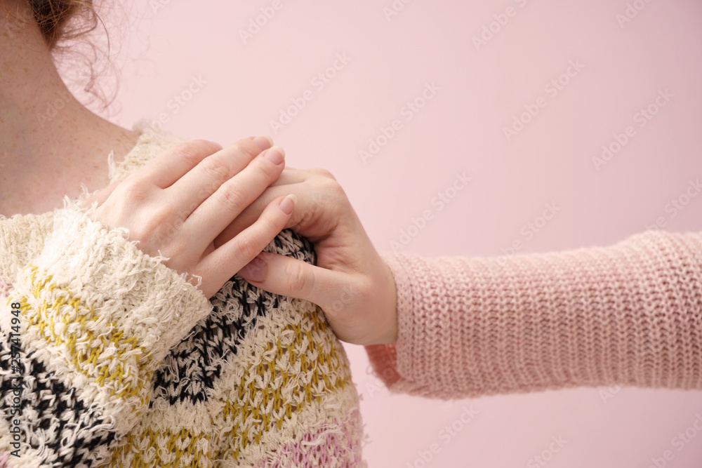 年轻女子在彩色背景上安慰她的朋友