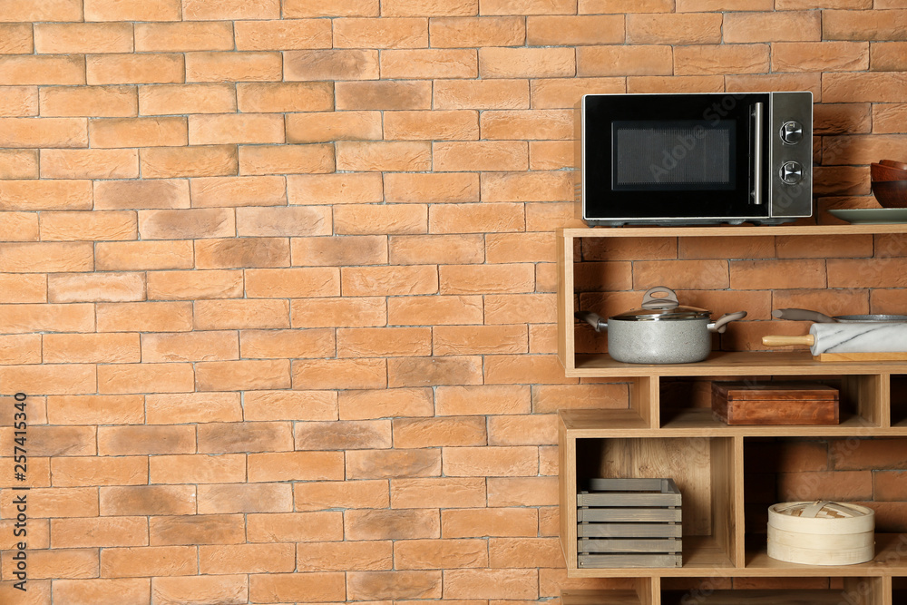 Shelf unit in kitchen near brick wall