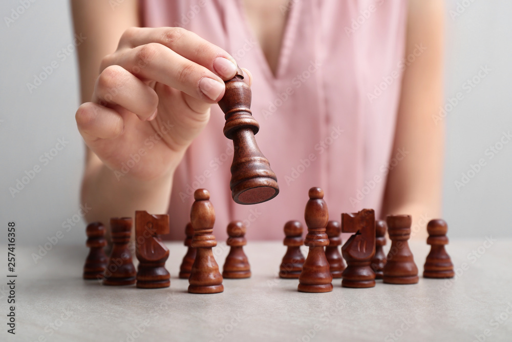 Woman with chess pieces at table. Concept of developing strategy for career growth